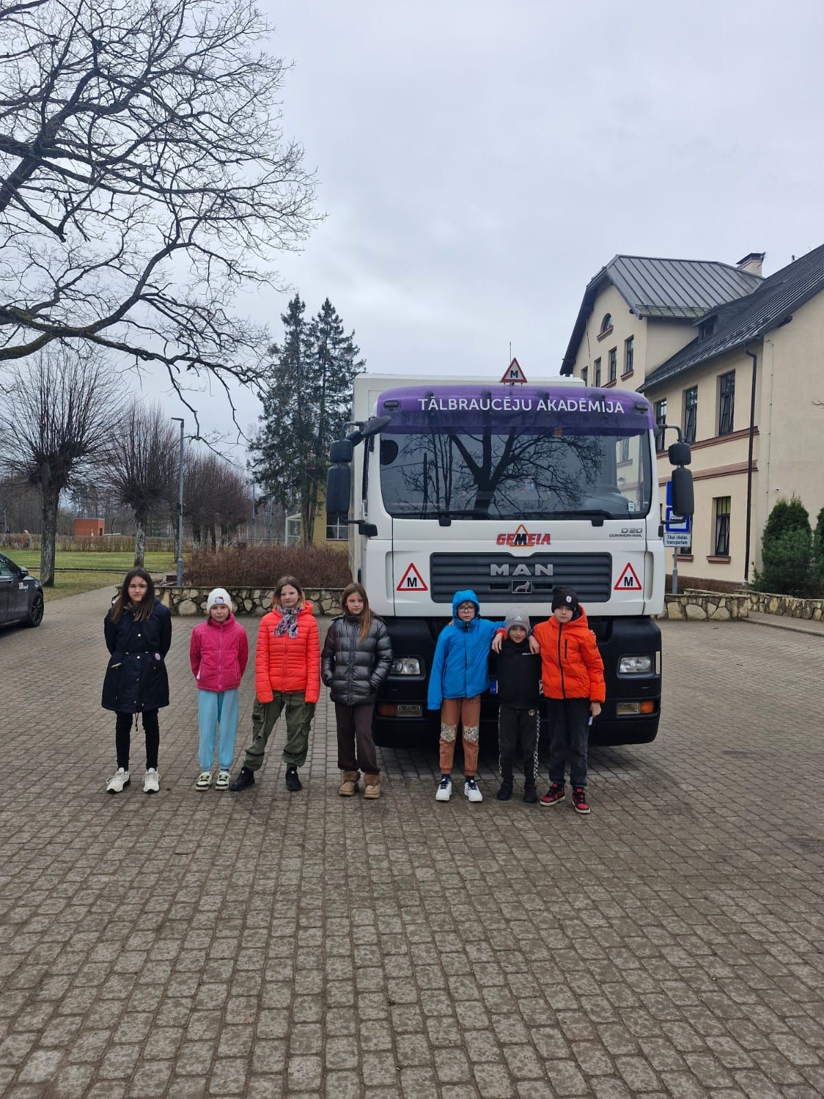 Skolēni pie C kategorijas kravas auto